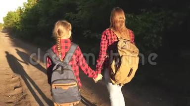 徒步旅行者女孩。 带背包的女孩在阳光下的乡村道路上。 体育旅游和旅游的概念。 儿童